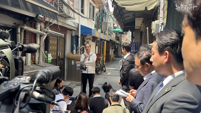 한덕수 전 국무총리가 2일 대선 출마 선언 후 첫 공개 일정으로 서울시 종로구 돈의동 쪽방촌을 방문했다. 사진은 한 전 총리가 쪽방촌 골목에서 '백브리핑'을 열고 질문에 답변하는 장면이다.