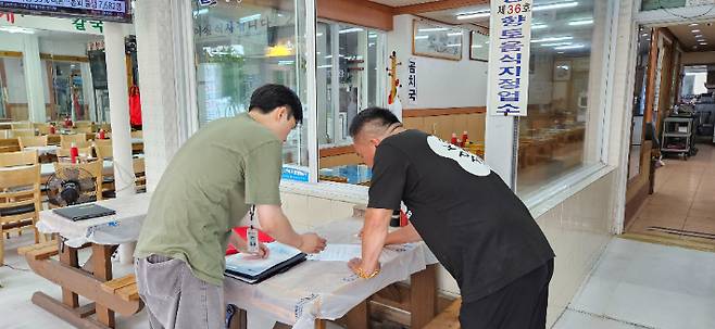 경포해변 호객행위 금지 서명부에 동참하고 있는 한 상인. 강릉시 제공