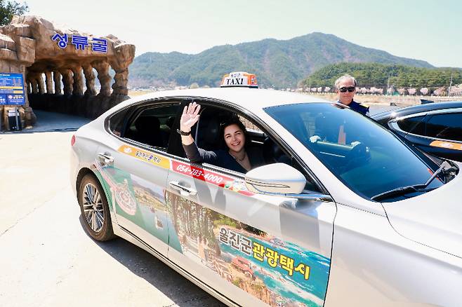 울진을 찾은 외국인이 울진 관광택시를 타고 성류굴을 방문한 뒤 인사하고 있다. 울진군 제공