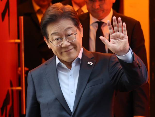 이재명 더불어민주당 대선 후보가 1일 서울 종로구의 한 포차 식당에서 '당신의 하루를 만드는, 보이지 않는 영웅들'이란 주제로 열린 배달 라이더, 택배 기사 등 비(非)전형 노동자들과 간담회를 마친 뒤 이동하며 손인사를 하고 있다. 조태형기자