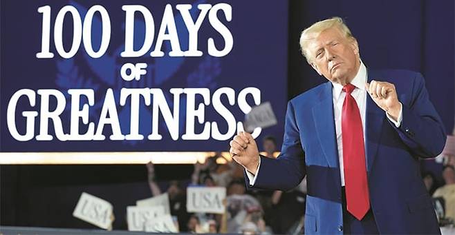 지난 29일 도널드 트럼프 미 대통령이 미시간주 머콤 카운티의 한 실내 체육관 내 ‘위대한 100일(100 days of greatness)’이라고 적힌 화면 앞에서 특유의 춤 동작을 하고 있다. /AP 연합뉴스