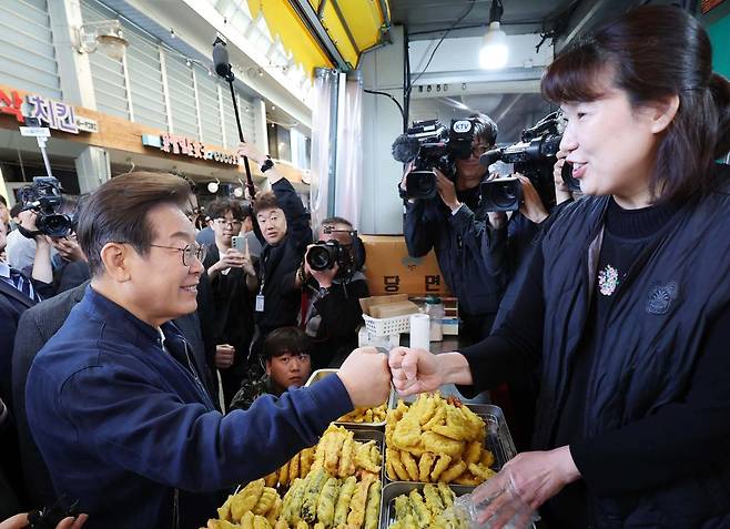 더불어민주당 이재명 대선 후보(왼쪽)가 ‘골목골목 경청투어’ 접경지역 방문 이틀째인 2일 강원 철원군 동송전통시장에 위치한 분식집을 찾아 상인과 주먹을 맞대고 있다. 철원=뉴스1