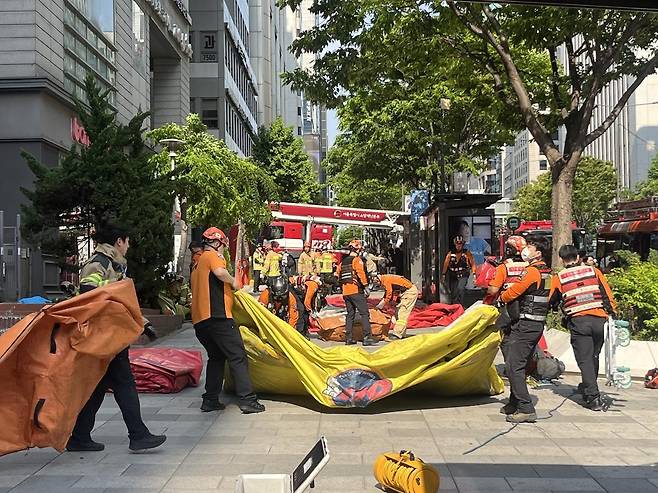 서울 강남구 역삼동 한 오피스텔 앞에 설치한 에어매트를 소방 관계자들이 정리하고 있다. 뉴스1