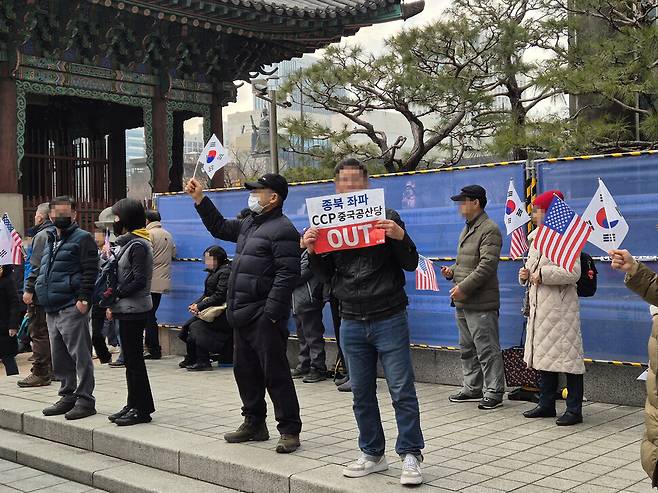 지난 3월1일 서울 시청앞 광장에서 열린 윤석열 탄핵 반대 시위 참가자들이 태극기와 성조기를 흔드는 가운데, 한 시민이 2020년 총선이 중국이 개입한 부정선거라는 근거 없는 이유로 ‘중국 공산당 아웃’이라고 쓴 손팻말을 들어보이고 있다. 조일준 선임기자