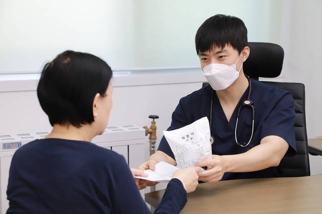 ▲ 사진은 봉오의원 군의관이 지역주민에게 약 복용방법을 설명하고 약을 건내주고 있다.