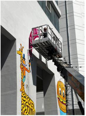 짐 아비뇽 작가가 광안리해수욕장 인근에 위치한 포디움다이브 건물 벽에 그림을 그리는 모습. 포디움다이브M 제공