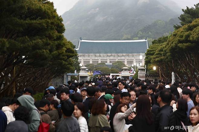 [서울=뉴시스] 김근수 기자 = 청와대 밤마실 야간개방 첫 날인 1일 서울 종로구 청와대 입구에서 입장을 기다리고 있다.   청와대재단은 1일부터 6일까지 청와대 야간 개방 행사인 '청와대 밤마실'을 진행한다. 이 행사에서는 전통 문양을 활용한 조명으로 꾸민 본관 '청와단청'과 관람객 움직임에 반응하는 '빛의 길', 숲속 같은 느낌의 '빛의 숲', 음악과 조명이 어우러진 관저의 '빛의 정원' 등 다양한 프로그램이 제공된다. 행사는 매일 오후 7시부터 9시까지 진행된다. 2025.05.01. ks@newsis.com /사진=김근수