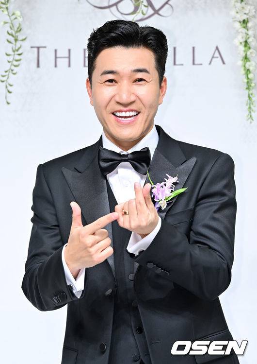 [OSEN=박준형 기자] 가수 김종민은 20일 서울 중구 장충동 신라호텔 영빈관에서 11살 연하 예비 신부와 결혼식을 올린다.예비 신부가 비연예인인 만큼 혼자 포토월에 서는 김종민은 간단한 인터뷰에 응하며 간단한 소감을 전했다. 김종민이 포즈를 취하고 있다.   2025.04.20 / soul1014@osen.co.kr