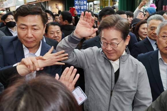 더불어민주당 이재명 대선 후보가 ‘골목골목 경청투어’ 사흘째인 3일 강원도 양양군 양양시장에서 도민들과 악수 등 접촉을 피하며 인사를 나누고 있다. 2025.5.3 연합뉴스