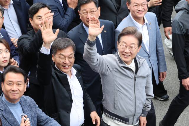 이재명(오른쪽) 더불어민주당 대선 후보가 3일 '골목골목 경청투어' 사흘째인 3일 강원도 동해안 지역의 민심을 공략하기 위해 강릉 안목해변 커피거리를 찾아 도민과 관광객들을 향해 인사하고 있다. 연합뉴스