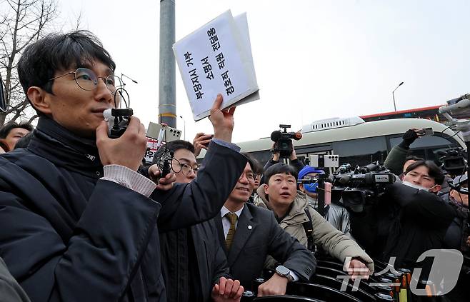 서울중앙지법 판사 출신 차성안 서울시립대 법학전문대학원 교수(왼쪽)와 윤석열체포변호사단이 지난 1월 13일 오후 서울 용산구 한남동 대통령 관저에서 경호처 직원들에게 전달할 '부당지시 거부 소명서'를 들어 보이고 있다. 변호인단은 "수사당국의 윤 대통령 체포영장 집행을 물리적으로 막으라는 명령은 부당 지시에 해당해 법적인 복종의무가 없다＂며 경호처 직원들에게 지시 불이행을 촉구했다. 2025.1.13/뉴스1 ⓒ News1 장수영 기자