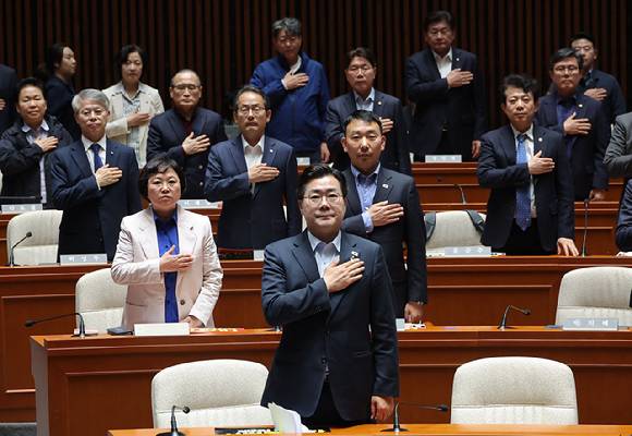더불어민주당 박찬대 원내대표를 비롯한 의원들이 4일 국회에서 열린 긴급 의원총회에서 국기에 경례를 하고 있다. 2025.5.4  [사진=연합뉴스]