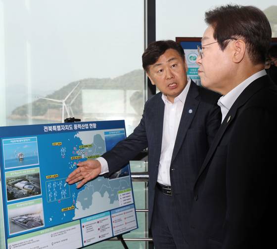 이재명 더불어민주당 대선 후보가 지난달 24일 전북자치도 김제시 새만금 33센터에서 열린 미래에너지 현장 간담회를 마친 뒤 김관영 전북지사에게 전북 풍력산업 현황에 대한 설명을 듣고 있다. 뉴스1
