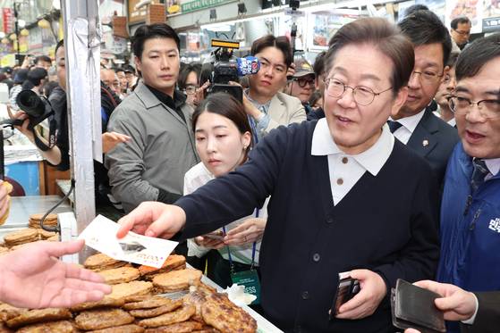 더불어민주당 이재명 대선 후보가 '골목골목 경청투어' : 단양8경편'에 나선 4일 충북 단양군 단양구경시장에서 떡갈비를 사먹으면서 지역화폐를 사용하고 있다. 연합뉴스