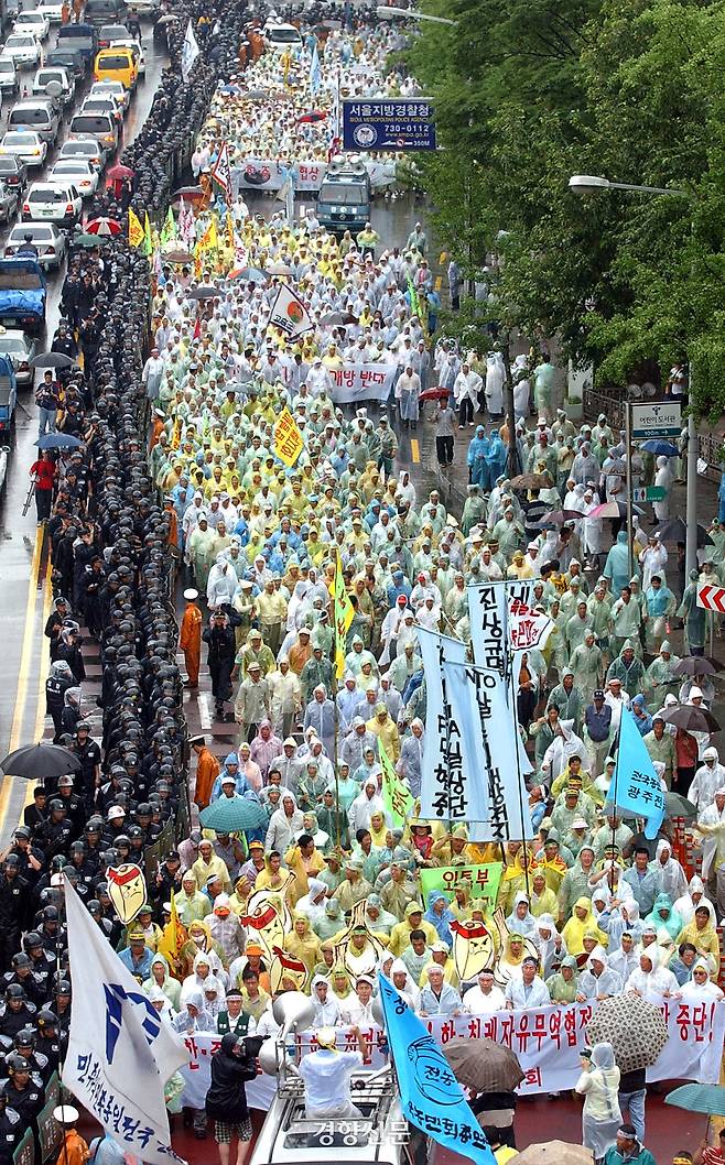 2002년 7월22일 전국에서 상경한 4000여명의 농민들이 서울 사직공원에서 비가 내리는 가운데 한·중 마늘 비밀협상 규탄집회를 갖고 정부의 보상 및 세이프가드 연장 등을 촉구하며 시위행진을 벌이고 있다. 경향신문 자료사진