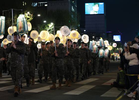Military soldiers carry bell-shaped and circular lanterns in downtown Seoul during the Lotus Lantern Festival on April 26, an event to celebrate Buddha's Birthday, which falls on May 5 this year. [YONHAP]