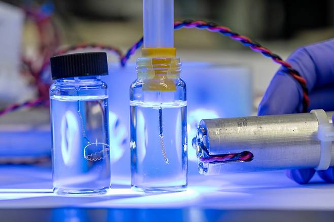 AC-LCE 소재로 만든 스프링 구조 인공근육에 자외선을 비춰 동작을 유도하는 모습. 한국화학연구원