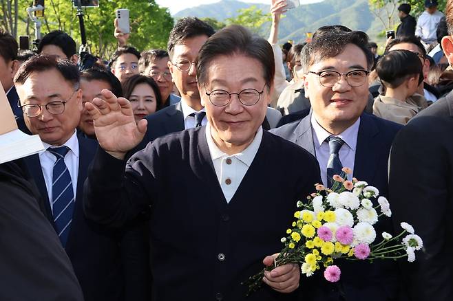 더불어민주당 이재명 대선 후보가 ‘골목골목 경청투어’ : 단양8경편‘에 나선 4일 충북 제천군 의림지를 찾아 한 지지자가 준 꽃을 들고 인사하고 있다. [사진출처 = 연합뉴스]