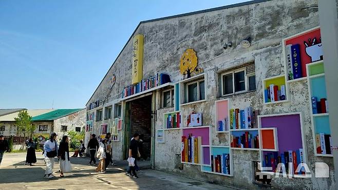 [청주=뉴시스] 충북 청주시와 청주시문화산업진흥재단은 4일 동부창고 일대에서 문화도시조성사업 '아카이브 시티 프로젝트' 기념식을 열었다. 동부창고 벽면에 문화도시 청주 5년의 사업들을 책으로 기록해 전시했다. (사진= 청주문화재단 제공) 2025.05.04. photo@newsis.com   *재판매 및 DB 금지