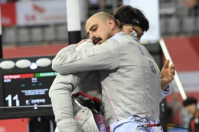 오상욱(왼쪽)이 경기를 끝낸 모습. /사진=국제펜싱연맹