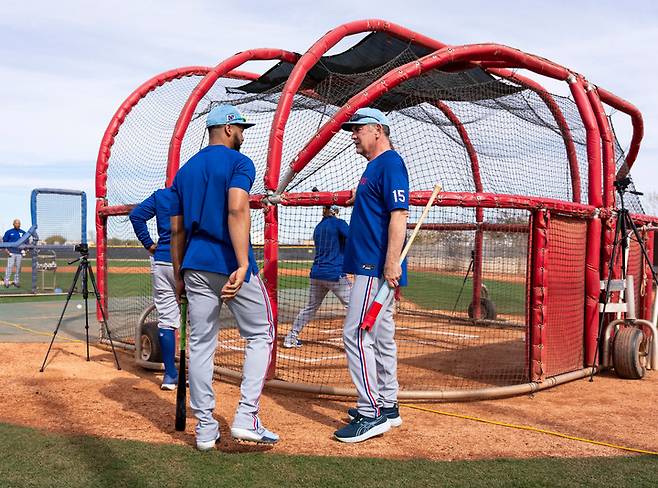 (브루스 보치 텍사스 감독(오른쪽)이 스프링캠프에서 타자들의 타격훈련을 살펴보고 있다)