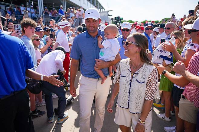 스코티 셰플러가 아들 베넷을 안고 아내 메레디스와 함께 시상식장으로 이동하고 있다./Raymond Carlin III-Imagn Images 연합뉴스