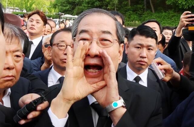 2일 오후 광주 북구 국립 5·18 민주묘지를 찾은 한덕수 전 총리가 광주비상행동 등 시민·사회단체 관계자들의 반발에 가로막히자 \"저도 호남 사람\"이라며 참배를 호소하고 있다. 연합뉴스