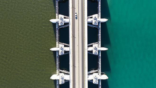 새만금방조제 가력배수갑문 바깥(오른쪽) 바닷물은 진초록이지만, 안쪽 호수의 물은 적조의 영향으로 검붉어 색깔 차이가 선명하다. 중앙포토