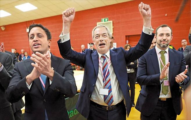 < ‘친트럼프’ 영국개혁당 압승 > 2일(현지시간) 나이절 패라지 영국개혁당 대표(가운데)가 위드니스의 핼턴 스타디움에서 열린 런콘·헬스비 보궐선거에서 승리하자 환호하고 있다. 로이터통신은 “패라지 대표의 승리는 ‘트럼프식 포퓰리즘’을 앞세운 개혁당의 부상을 상징적으로 보여주는 장면”이라고 평가했다.  로이터연합뉴스