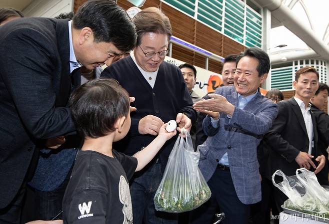 (영월=뉴스1) 이재명 기자 = '골목골목 경청투어 : 단양팔경편'에 나선 이재명 더불어민주당 대통령 후보가 4일 오후 강원 영월군 영월서부시장에서 한 어린이의 떡 선물을 받고 있다. 2025.5.4/뉴스1  Copyright (C) 뉴스1. All rights reserved. 무단 전재 및 재배포,  AI학습 이용 금지. /사진=(영월=뉴스1) 이재명 기자