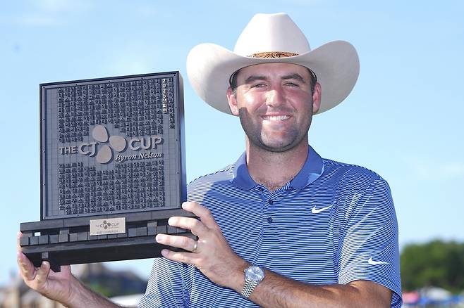 스코티 셰플러가 PGA 투어 더 CJ컵 바이런 넬슨 정상에 오른 뒤 카우보이 모자를 쓴 채 우승컵을 들고 활짝 웃고 있다.   [AP]