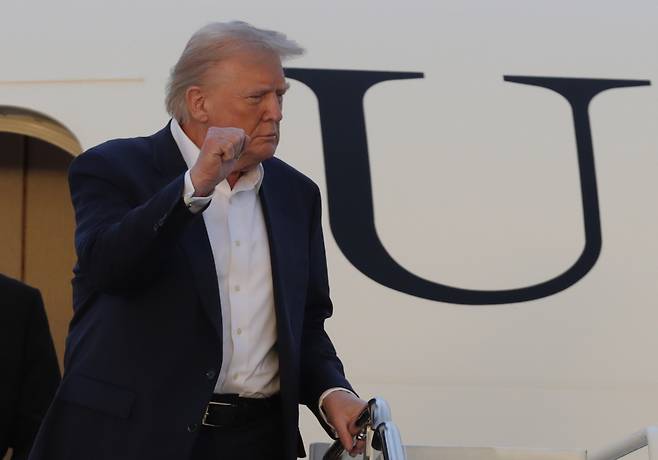 도널드 트럼프 미국 대통령이 4일(현지시간) 메릴랜드주 앤드류스 합동기지에 도착한 후 에어포스원 계단에서 손을 번쩍 들어올리고 있다. [AP]