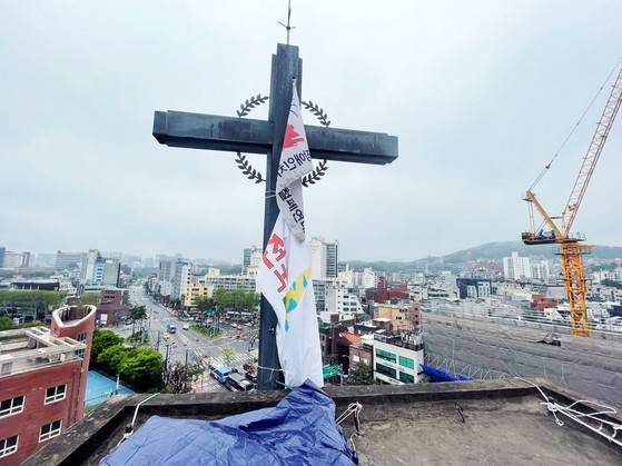 종로구 소재 혜화동성당의 종탑 위 십자가에 전국탈시설장애인연대 깃발. 사진 전국탈시설장애인연대