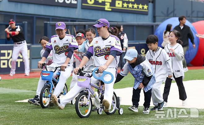 [서울=뉴시스] 김선웅 기자 = 어린이날인 5일 서울 송파구 잠실야구장에서 열린 2025 프로야구 LG 트윈스 vs 두산 베어스의 경기 시작 전 두산 박지훈, 김민석이 어린이용 자전거를 타고 어린이날 기념 미니 운동회에 참여하고 있다. 2025.05.05. mangusta@newsis.com