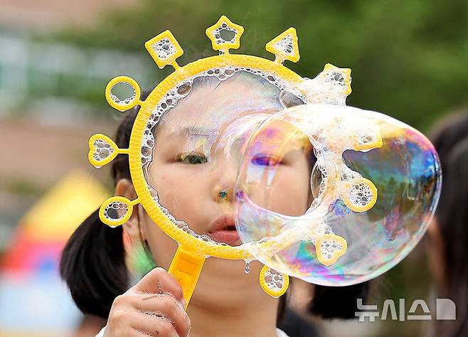 [대구=뉴시스] 이무열 기자 = 103주년 어린이날인 5일 대구 수성구 대구어린이세상에서 한 어린이가 비눗방울 놀이를 하며 즐거워하고 있다. 2025.05.05. lmy@newsis.com