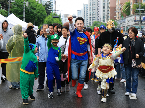 슈퍼맨으로 변신한 오언석(가운데) 서울 도봉구청장이 지난 3일 도봉구청 앞 마들로 일대에서 어린이들과 함께 캐릭터 퍼레이드를 선보이고 있다. 도봉구 제공