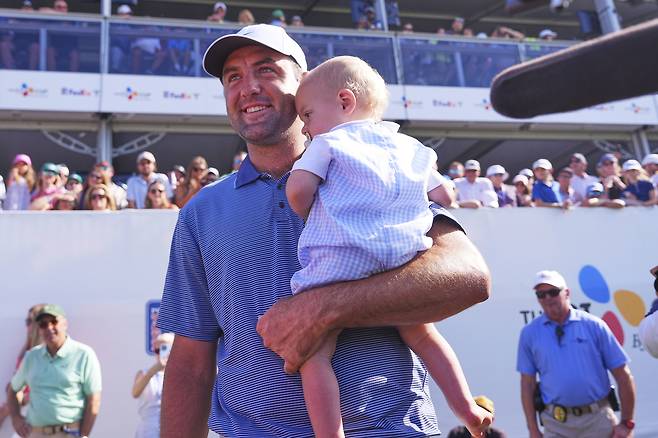 스코티 셰플러가 5일 미국 텍사스주 댈러스 인근 맥키니의 TPC 크레이그 랜치에서 열린 PGA 투어 CJ컵 바이런 넬슨 최종라운드에서 8타차 압승으로 시즌 첫승을 거둔 뒤 18번홀 그린에서 아들 베넷을 안고 미소짓고 있다. 맥키니｜AP연합뉴스