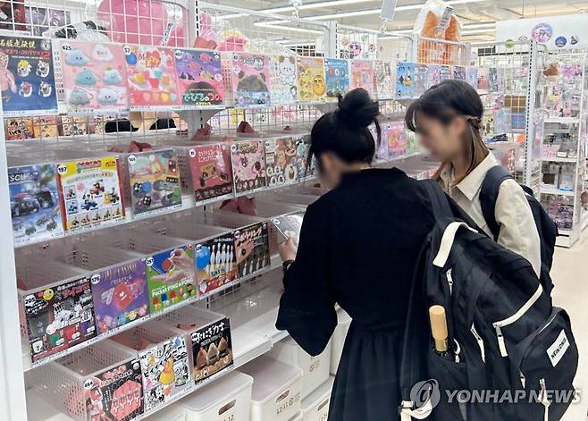 이거 한번 뽑아 볼까 (서울=연합뉴스) 김유진 인턴기자 = 지난달 28일 오후 서울 홍대의 한 가챠숍에서 고객들이 가챠(캡슐 토이)를 구경하고 있다. 2025.5.5