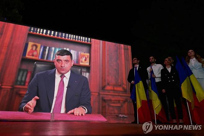 루마니아 민족주의 정당 AUR의 제오르제 시미온 대선후보 (부쿠레슈티 AFP=연합뉴스) 4일(현지시간) 루마니아 대선 1차 투표 종료 직후 제1야당 결속동맹(AUR) 지지자들이 제오르제 시미온 후보의 영상 연설을 듣고 있다. 2025.5.4 photo@yna.co.kr