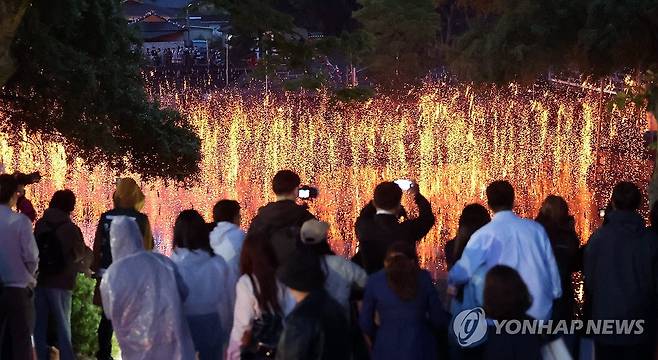 어둠 밝히는 함안낙화놀이 (함안=연합뉴스) 김동민 기자 = 부처님오신날이자 어린이날인 5일 오후 경남 함안군 함안면 무진정에서 '제32회 함안낙화놀이 공개행사'가 열리고 있다.
    숯과 한지를 꼬아 만든 낙화봉 수천 개를 줄에 매달아 놓고 일몰 무렵 불을 붙이는 민속놀이다. 2025.5.5 image@yna.co.kr