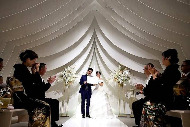 일본 예식 업체 '렉'은 최근 7만엔대에 식을 올릴 수 있는 대여 서비스를 제공 중이다. 사진은 최근 후쿠오카 점포에서 열린 결혼식 장면. 부부가 하객들 앞에서 혼인 서약을 읽고 있다./렉