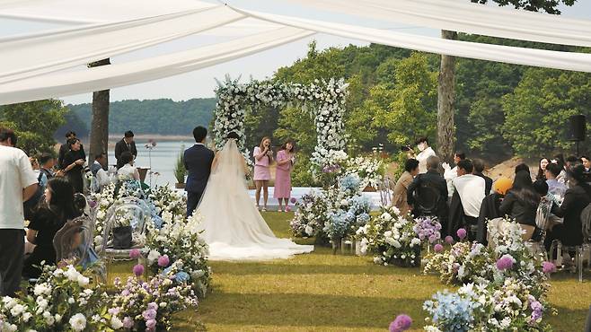 충북 청주시 청남대에서 대청호를 배경으로 야외 결혼식이 진행 중인 모습. 하객 150명을 초대할 수 있는 이 공공 예식장은 정부 공유누리 사이트 등을 통해 예약·문의하면 관리 기관 심사를 거쳐 이용할 수 있다. 이용료는 4시간에 50만원이다./청남대관리사업소 홈페이지