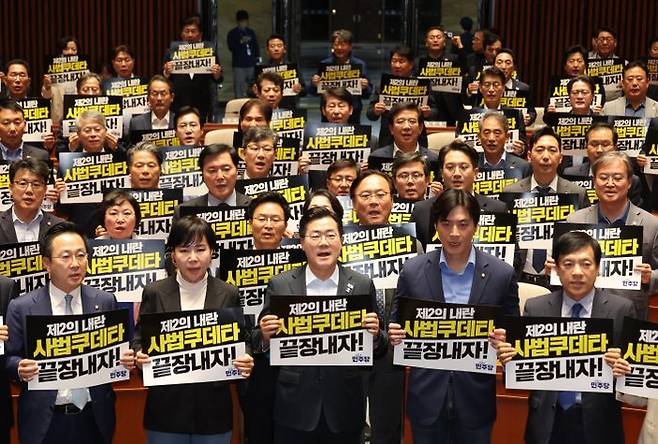 더불어민주당 박찬대 대표직무대행 겸 원내대표와 의원들이 4일 국회에서 열린 긴급 의원총회에서 피켓을 들고 구호를 외치고 있다. ⓒ뉴시스