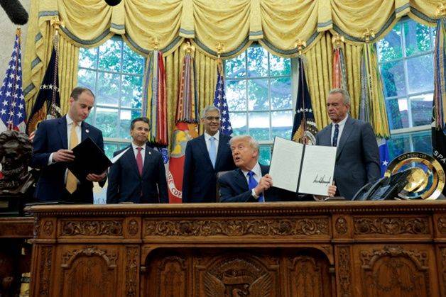 도널드 트럼프 미국 대통령이 5일(현지시간) 백악관 집무실에서 의약품 제조 촉진 관련 행정명령에 서명한 뒤 서명된 문서를 보여주고 있다. ⓒ AFP/연합뉴스