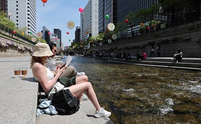 초여름에 가까운 날씨를 보인 30일 오후 서울 청계천을 찾은 외국인 관광객이 가벼운 옷차림으로 휴식을 취하고 있다. 2025.4.30/뉴스1