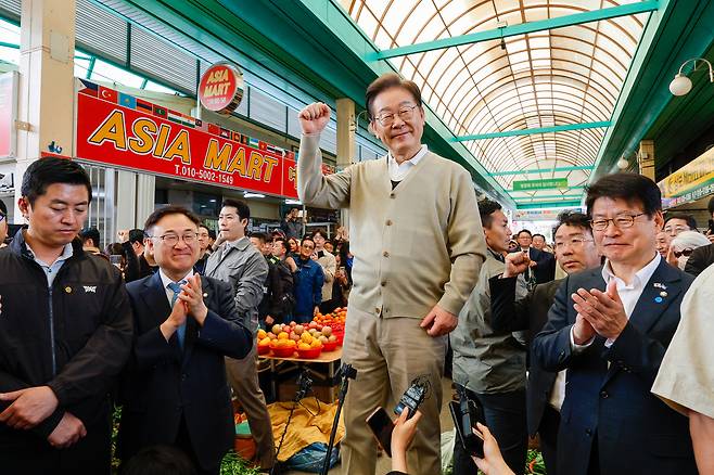 Democratic Party presidential candidate Lee Jae-myung, center, visits a traditional market in Jeungpyeong County, about 100 kilometers southeast of Seoul, on May 6. [YONHAP]