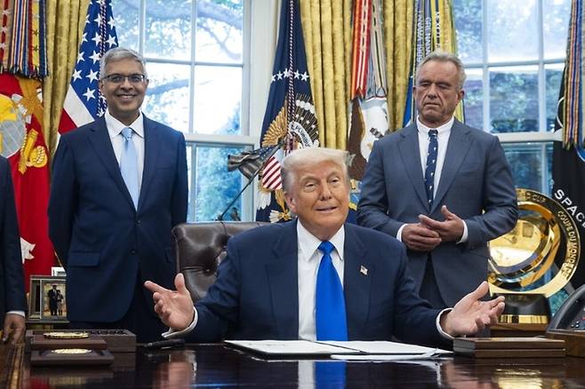 도널드 트럼프 미국 대통령(가운데)이 제이 바타차리아 국립보건원 원장(왼쪽)과 로버트 F 케네디 주니어 보건복지부 장관이 배석한 가운데 5일(현지시간) 워싱턴DC 백악관 집무실에서 보건·의약품 관련 행정명령에 대해 설명하고 있다. EPA연합뉴스