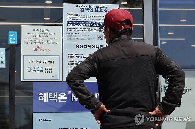 SKT 유심 해킹에 소비자는 근심 (서울=연합뉴스) 임화영 기자 = SK텔레콤이 가입자 유심(USIM) 정보 유출 사태로 오는 5일부터 신규 가입자 모집을 중단한다고 밝힌 2일 서울 시내의 한 SK텔레콤 대리점 앞에서 한 소비자가 유심 재고 소진 및 유심보호서비스 관련 안내문을 살펴보고 있다. 2025.5.2 hwayoung7@yna.co.kr