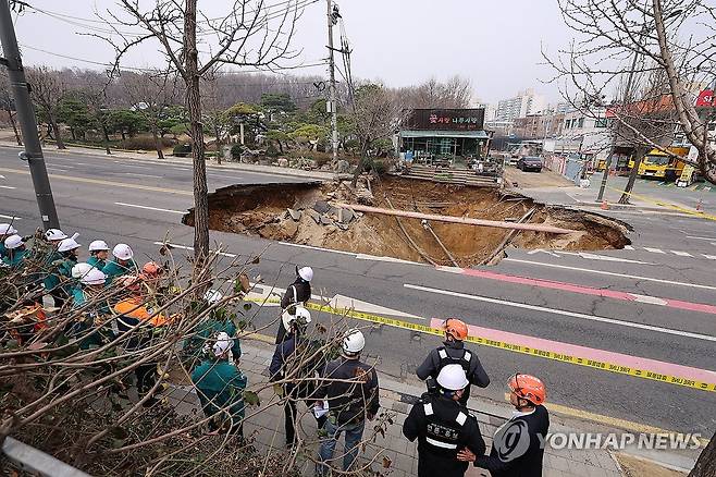 강동구 대형 땅꺼짐 현장 (서울=연합뉴스) 서대연 기자 = 25일 강동구 대명초등학교 도로에서 전날 발생한 대형 땅꺼짐 현장의 모습. 
    전날 오후 명일동 대명초등학교 인근 사거리에서 발생한 지름 20ｍ, 깊이 18ｍ가량의 대형 싱크홀(땅꺼짐)에 오토바이 운전자 1명이 빠져 실종됐다. 2025.3.25 dwise@yna.co.kr