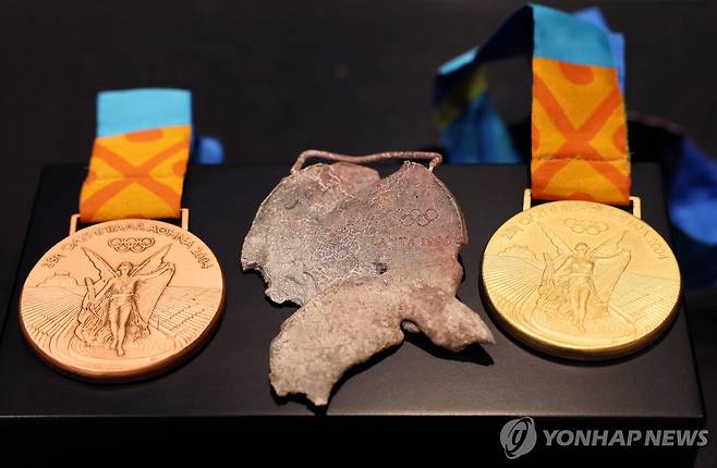 불에 녹은 메달 원본(가운데) [Denis Balibouse / POOL / AFP=연합뉴스]
